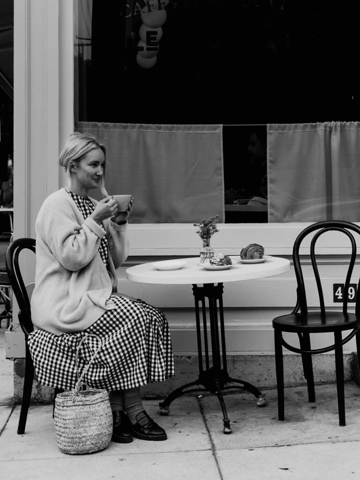 woman sitting at cafe drinking coffee