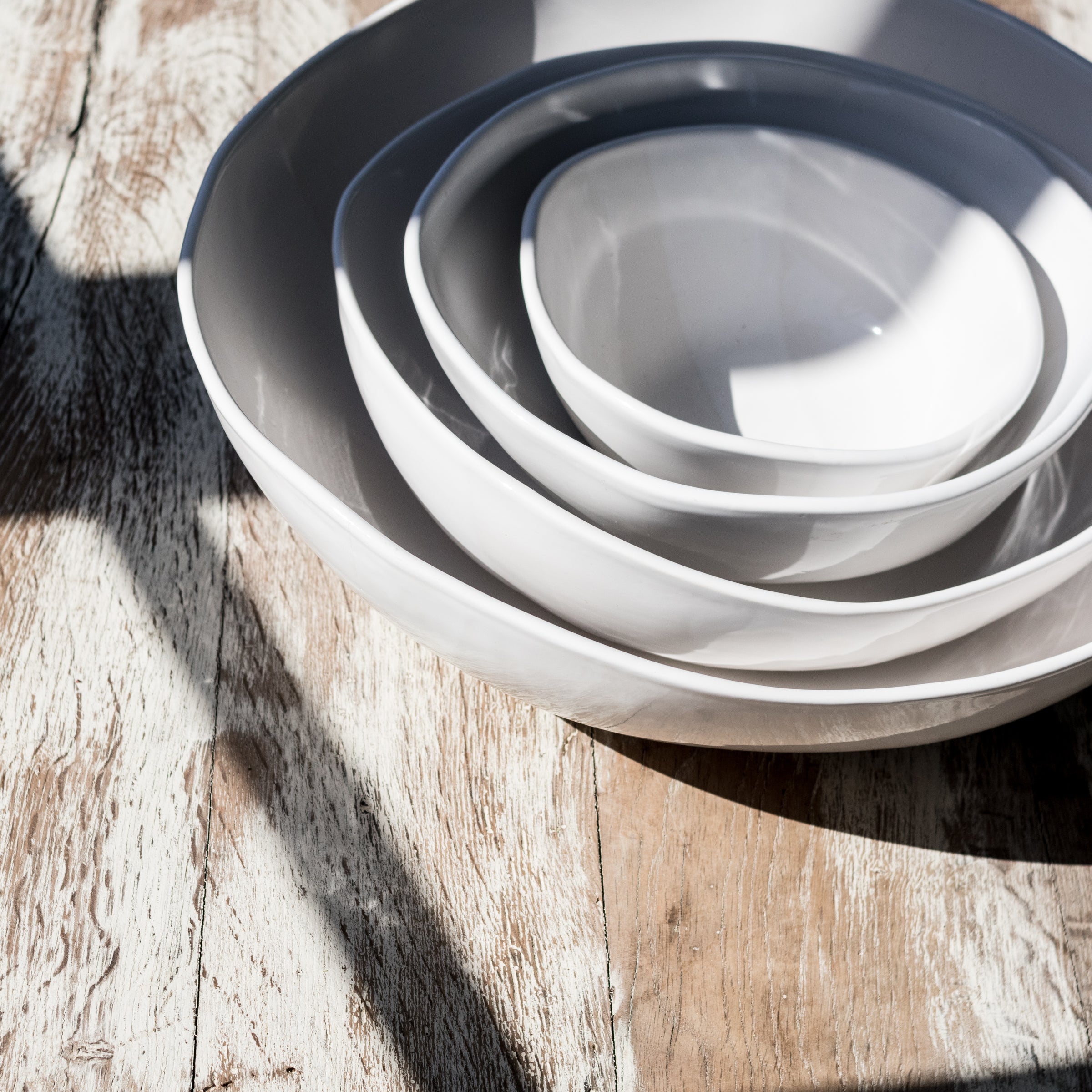 stack of white bowls in sunlight
