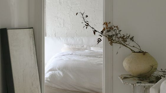 white bed in room with white walls