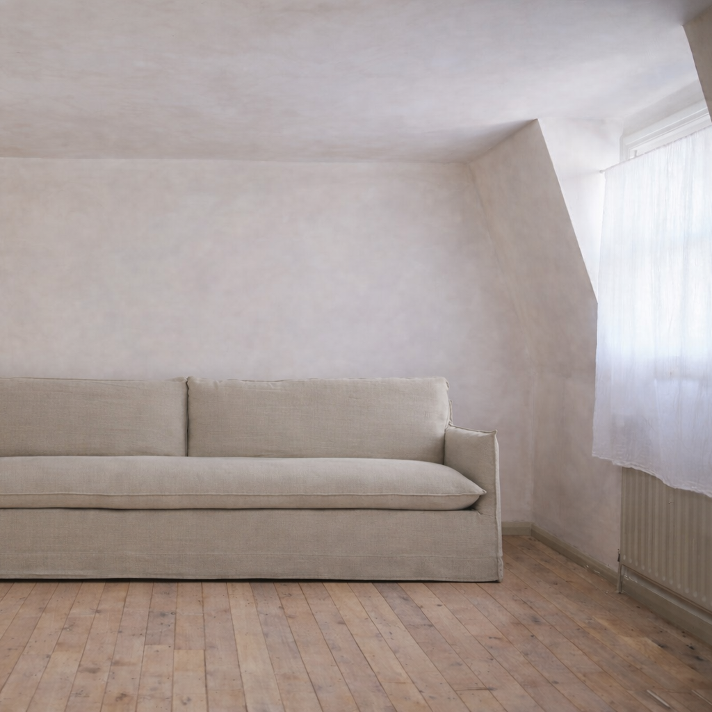 Beige sofa in a minimalistic room with wooden floor and white walls