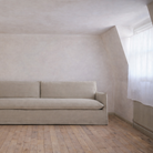 Beige sofa in a minimalistic room with wooden floor and white walls