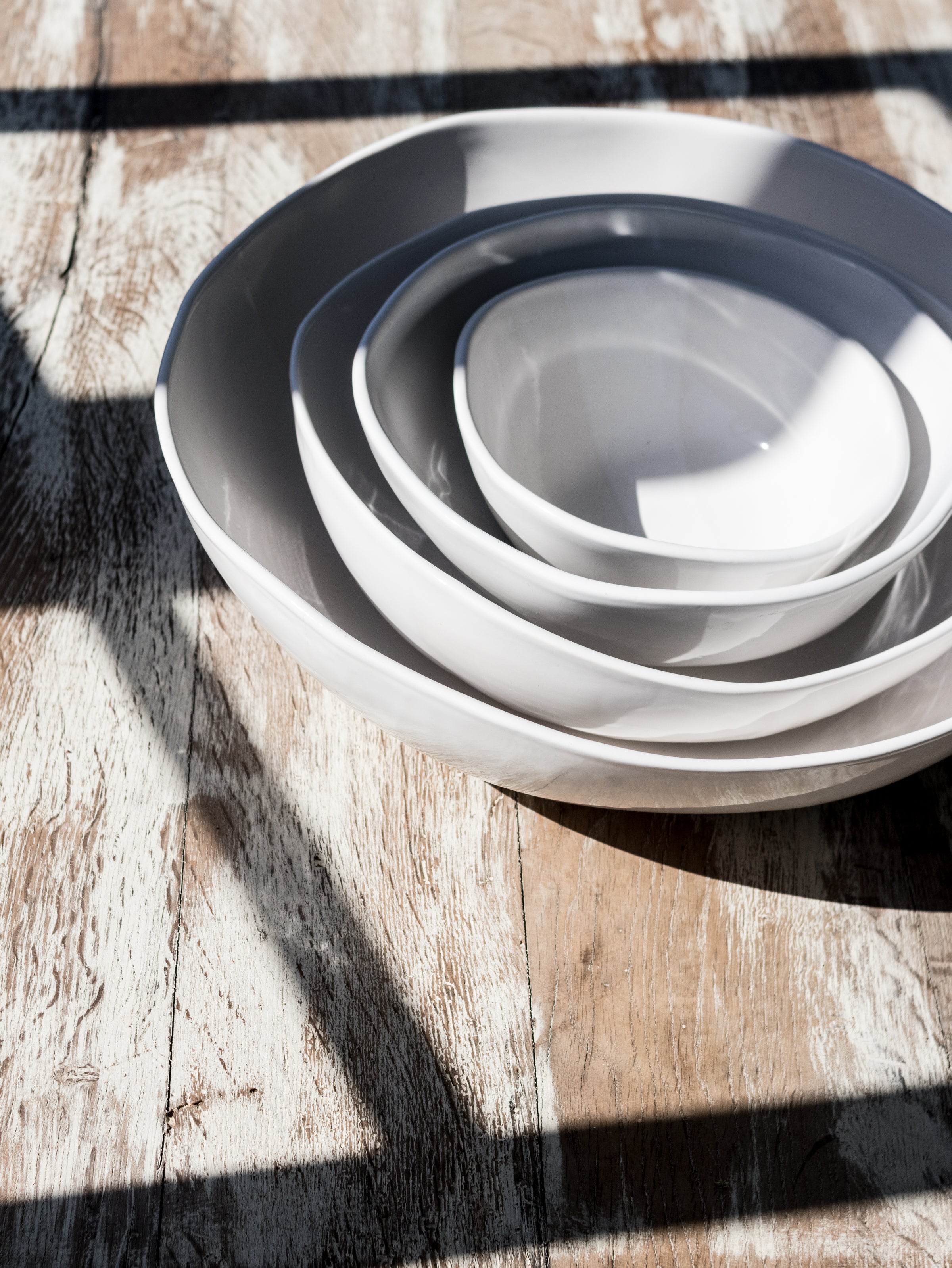 stack of white bowls in sunlight